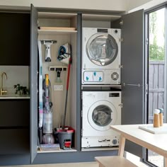 a washer and dryer are in an open cabinet next to the kitchen table