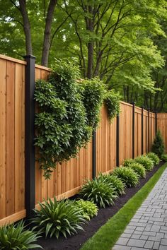 a wooden fence surrounded by lush green trees and plants on either side of the fence