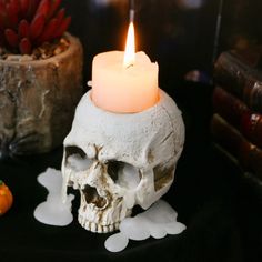 a candle that is on top of a skull