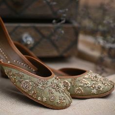 Set on a sage green silk base, with a delicate looking floral arabesque design. The traditional jaal style design has been skillfully hand-embroidered using gold zari, mini faux pearls and gold sequins. Outer material: Silk Inner material: Genuine Leather Color: Sage Type of work: Zardozi & Crystal Care: Dry Clean only.If the shoe gets wet, remember to first dry in the sun before putting it back in the closet. Punjabi Jutti Wedding, Wedding Ballet Flats, Indian Shoes, Shoes Ads, Punjabi Jutti, Christmas Shoes, Bridal Shoes Flats, Green Heels, Wedding Flats