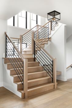 a wooden staircase with metal railing and handrail