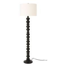 a black floor lamp with a white shade on the base and a cord attached to it