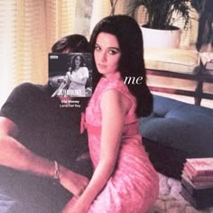 a man sitting next to a woman on top of a couch in front of a book