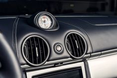 the dashboard of a car with two air vents on it's dash board and an analog clock