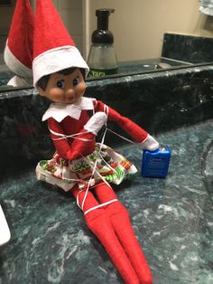 an elf sitting on top of a counter next to a sink