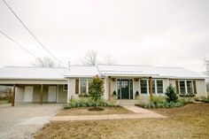 a house with a white roof and two garages