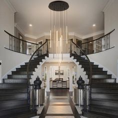 an elegant entry way with stairs and chandelier