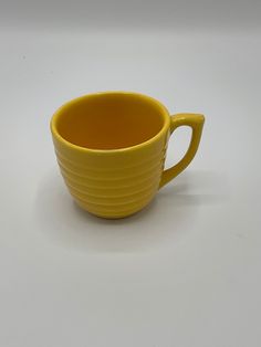 a yellow cup sitting on top of a white table