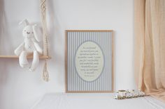 a white stuffed animal sitting on top of a bed next to a wooden frame with a poem