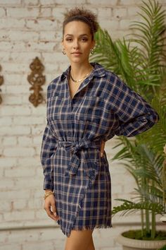 Plaid flannel shirt dress features frayed hem and tie waist.