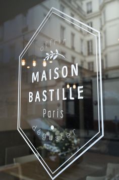 a glass sign that says maison bastille paris