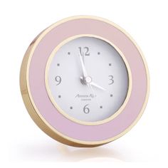 a pink and gold clock on a white background