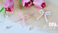 pink tulips and two cross brooches sitting on a white table cloth