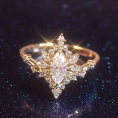 a diamond ring on a black surface with sparkles in the background and stars around it