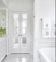 a large white bathroom with two sinks and a bathtub in the middle of it