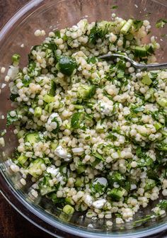 a glass bowl filled with couscous and vegetables