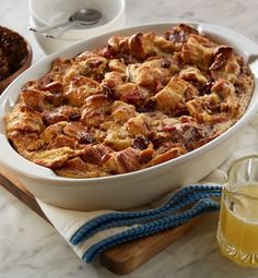 a casserole dish with bread and fruit on the side