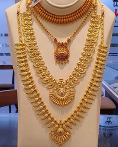 a gold necklace and earring set on display