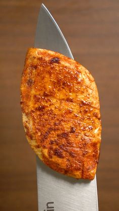 a piece of food sitting on top of a knife