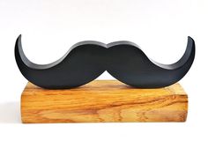 a wooden stand with a black moustache on it