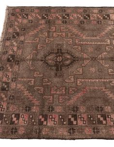 an old rug with many different patterns and colors on it, including pinks, browns, and browns