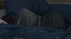 a person laying in bed with their head on the pillow