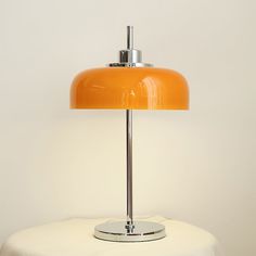 an orange lamp sitting on top of a white table