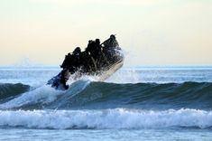 two people riding on top of a wave in the ocean