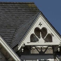 the top of an old building with a cross on it's roof and angel wings