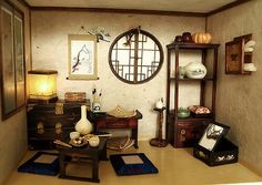 a living room filled with furniture and pictures on the wall next to a table topped with vases