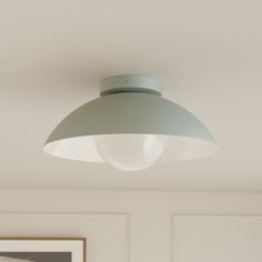 a light that is on the ceiling in a room with white walls and flooring