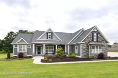 a large gray house sitting on top of a lush green field