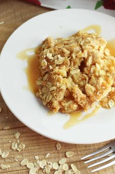 a white plate topped with oatmeal covered dessert on top of a wooden table