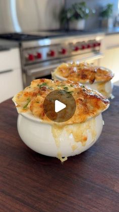 some food is sitting in a bowl on a table with a stove and oven behind it