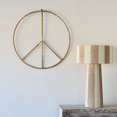 a peace sign hanging on the wall next to a lamp