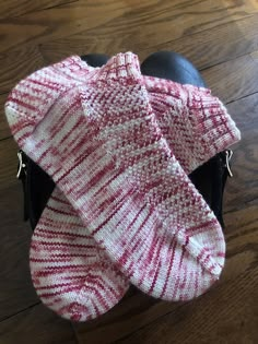 a red and white knitted scarf on top of a black bag