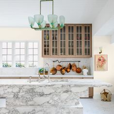 a kitchen with marble counter tops and wooden cabinetry in the center, along with an island