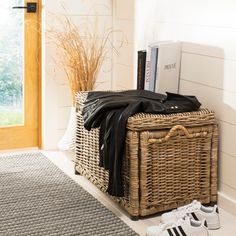 a wicker basket sitting on the floor next to a pair of shoes