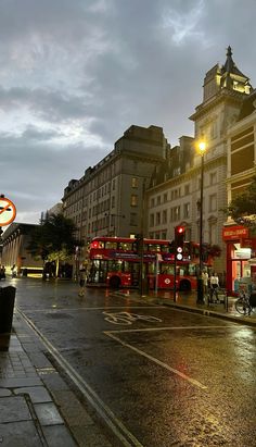 two double decker buses are parked on the side of the road in front of some buildings