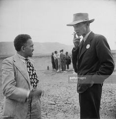 two men standing next to each other in the desert talking on their cell phones news photo