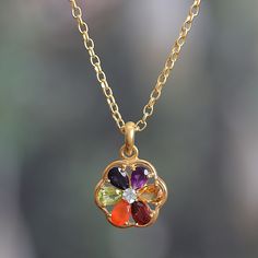 This floral medallion boasts multicolored petals to channel the energy of the seven chakras. Presented by Alok Jain, this 22k gold-plated necklace is ornamented with amethyst, iolite, citrine, peridot, garnet, blue topaz and carnelian jewels, totaling over three carats. In addition, each hue relates to a specific energy: purple is associated with wisdom, indigo to insight, and blue to truth. Green and red are for love and compassion. Inner power is represented by yellow and emotion by orange. Multicolor Multi-stone 22k Gold Jewelry, 14k Gold Gemstone Flower Pendant Jewelry, Spiritual Yellow Gold Multi-stone Necklace, Bohemian Gemstone Flower Pendant Jewelry, Golden Energy, Yellow Gold Multi-stone Spiritual Necklace, The Seven Chakras, Iolite Jewelry, Silver Chandelier Earrings