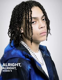 a young man with dreadlocks wearing a blue jacket