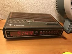 an alarm clock radio sitting on top of a wooden table