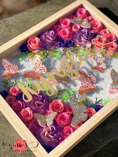 a wooden box filled with paper flowers and butterflies