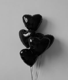 three black heart shaped balloons hanging on the wall