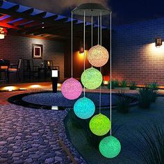 some lights that are hanging from the side of a house in the night time,