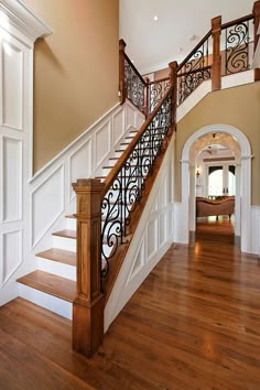 an entryway with wood floors and white railings on the second floor is shown