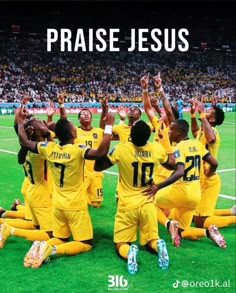 a group of soccer players sitting on the ground with their arms in the air and hands up