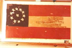 an old american flag hanging on a wall