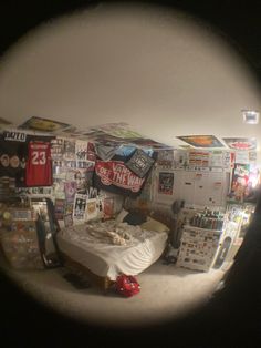 a bed sitting in a bedroom next to a wall covered in posters